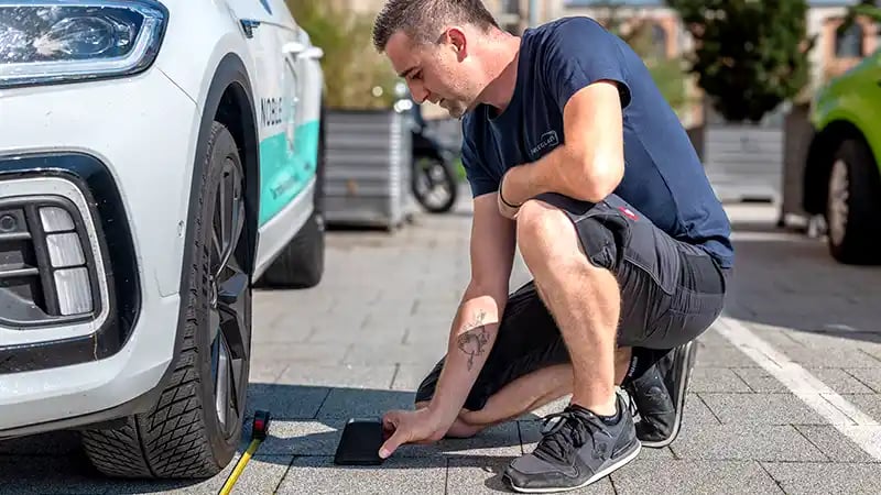 Nobleglass Autoglas-Monteur überprüft die Fahrzeugausrichtung für die Kalibrierung der Fahrerassistenzsysteme