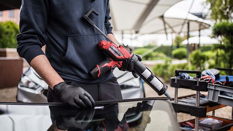nobleglass Monteur bringt Kleber auf Autoscheibe auf